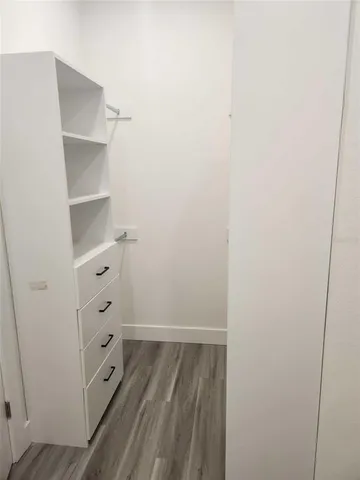 a view of walk in closet with empty racks