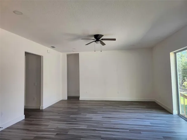 a view of room with hardwood floor and a ceiling fan