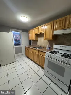 a kitchen with granite countertop a stove top oven a sink a counter space and cabinets