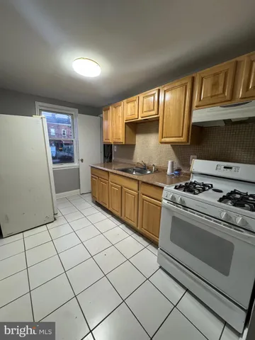 a kitchen with granite countertop a stove top oven a sink a counter space and cabinets