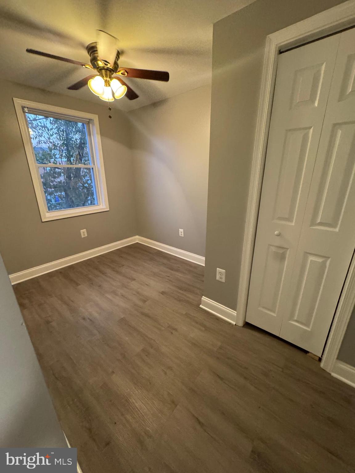 2705 Round Road Baltimore, MD 21225 - Photo 6 of 10 an empty room with wooden floor chandelier fan and windows