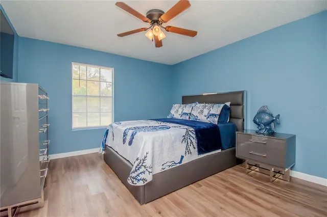 a bedroom with a bed and wooden floor