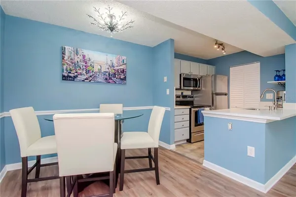 a living room with furniture a flat screen tv and kitchen view