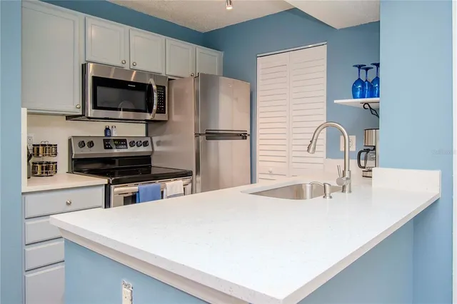 a kitchen with stainless steel appliances a microwave a stove and a sink
