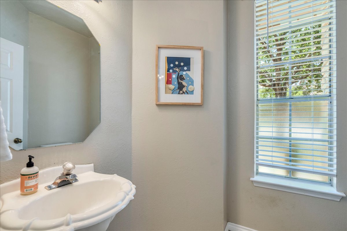 9300 Tea Rose Trail Austin, TX 78748 - Photo 18 of 33 A well-lit half bathroom offers privacy and convenience, with natural light filtering through the window blinds.