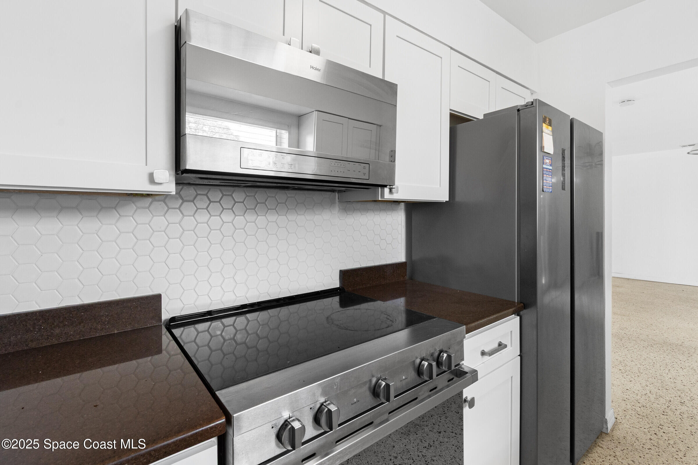 407 Bunker Street Melbourne, FL 32901 - Photo 12 of 26 a kitchen with stainless steel appliances granite countertop a refrigerator and a stove