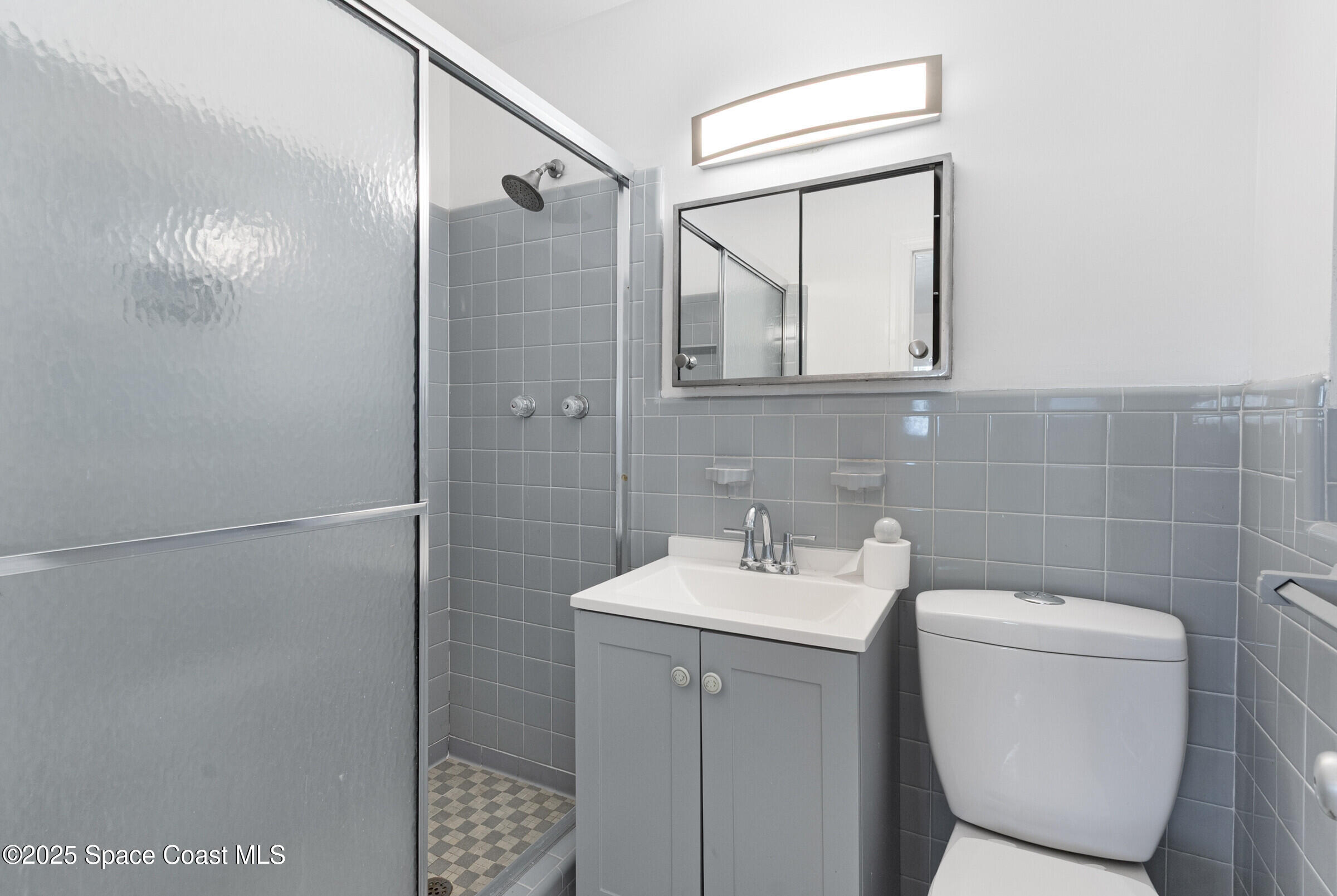 407 Bunker Street Melbourne, FL 32901 - Photo 16 of 26 a bathroom with a sink a toilet and shower