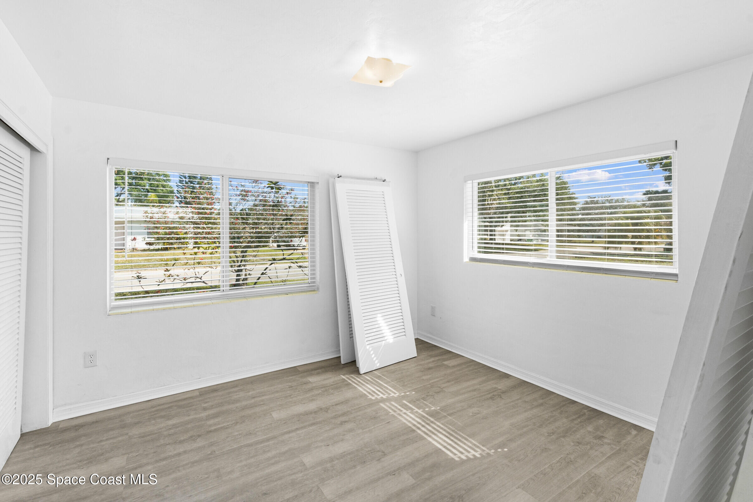 407 Bunker Street Melbourne, FL 32901 - Photo 19 of 26 a view of an empty room with wooden floor and a window