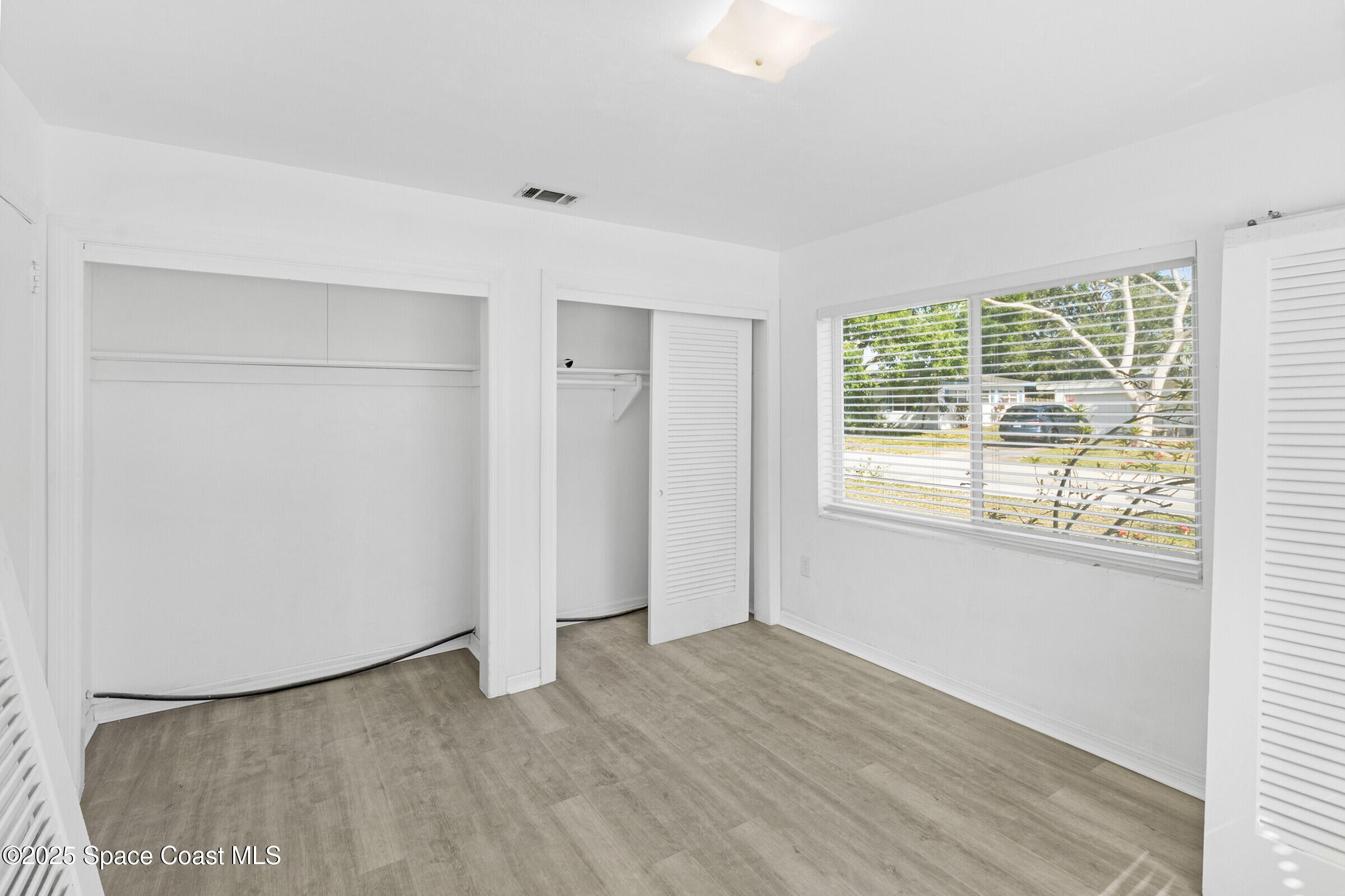 407 Bunker Street Melbourne, FL 32901 - Photo 20 of 26 a view of an empty room with wooden floor and a window
