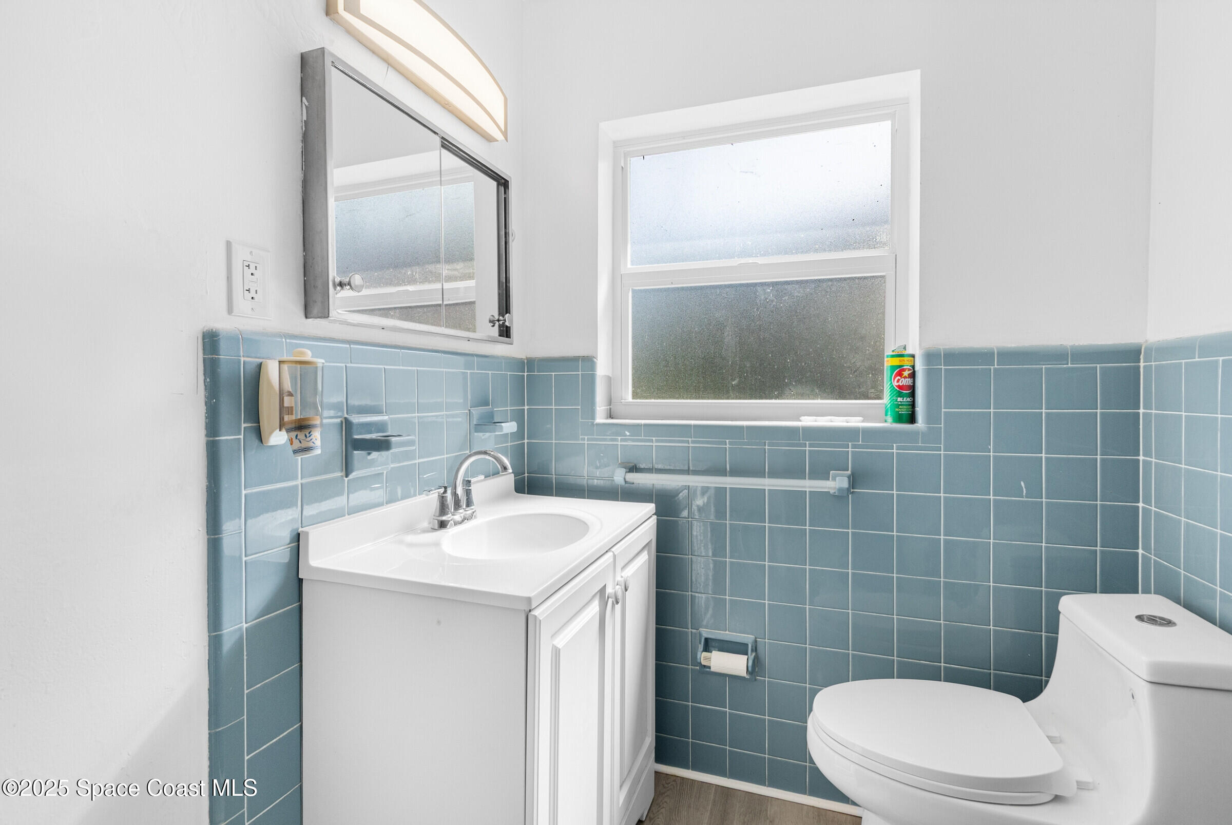 407 Bunker Street Melbourne, FL 32901 - Photo 21 of 26 a bathroom with a sink a toilet and mirror