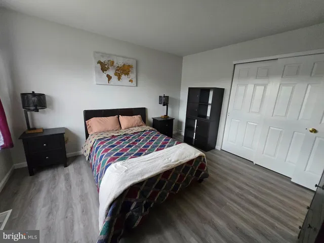 a bedroom with a bed and wooden floor