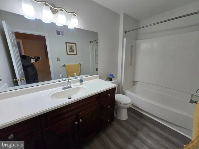 a bathroom with a double vanity sink toilet mirror and shower