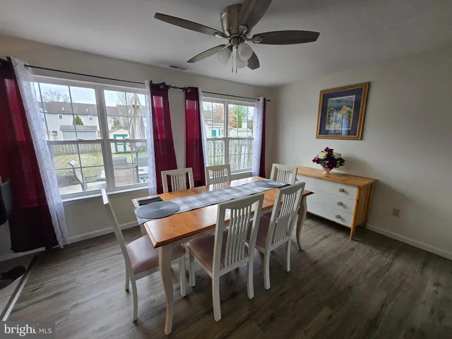 a dining room with furniture a chandelier and wooden floor