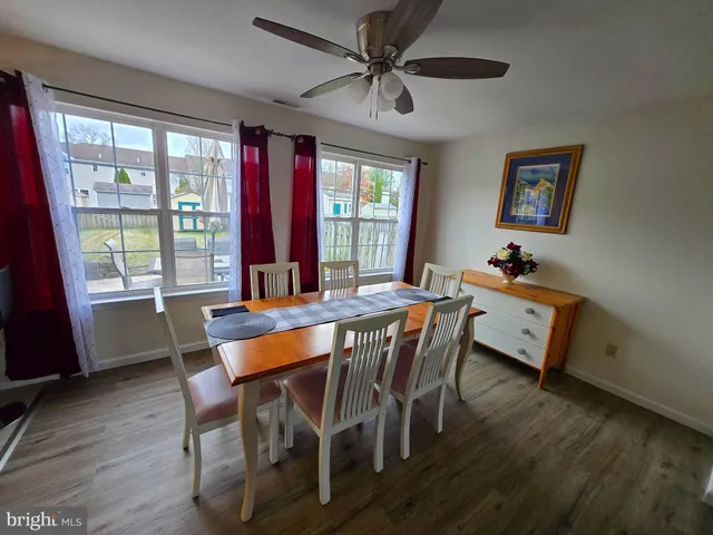 a dining room with furniture a chandelier and wooden floor