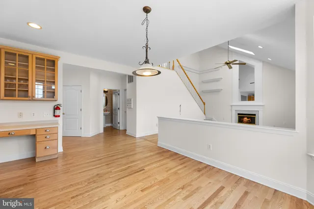 a view of a livingroom with wooden floor and a ceiling fan