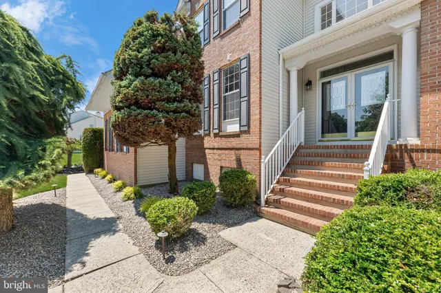 a view of a house with potted plants and a fountain