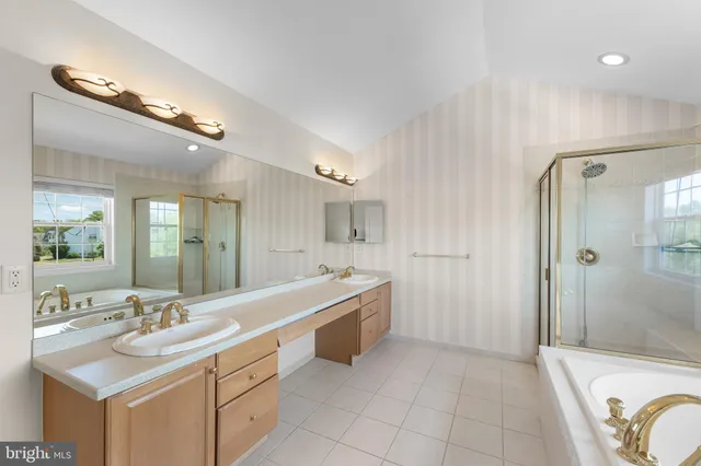 a spacious bathroom with a double vanity sink a mirror and a shower