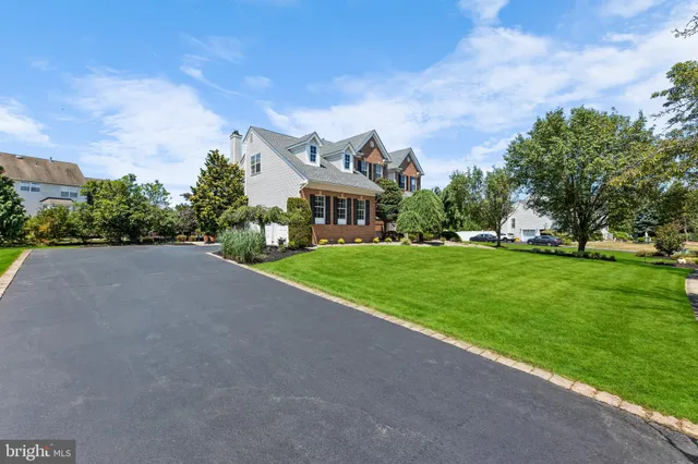 an aerial view of residential houses with outdoor space and trees
