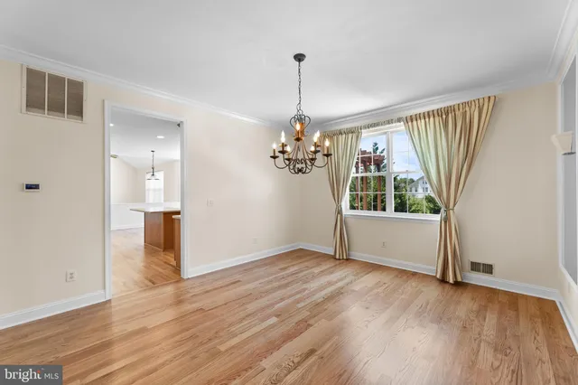 a view of a room with wooden floor chandeliers and kitchen