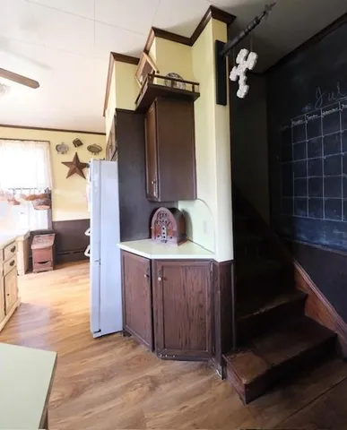 a kitchen with a refrigerator and a wooden floor