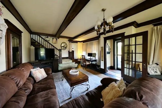 a living room with furniture a flat screen tv and a floor to ceiling window