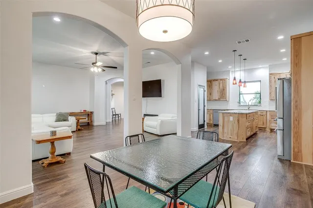 an open kitchen with wooden floor and stainless steel appliances
