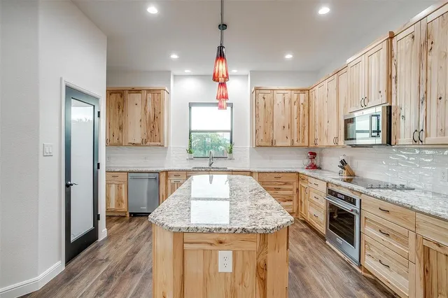 a kitchen that has a lot of cabinets in it and wooden floor
