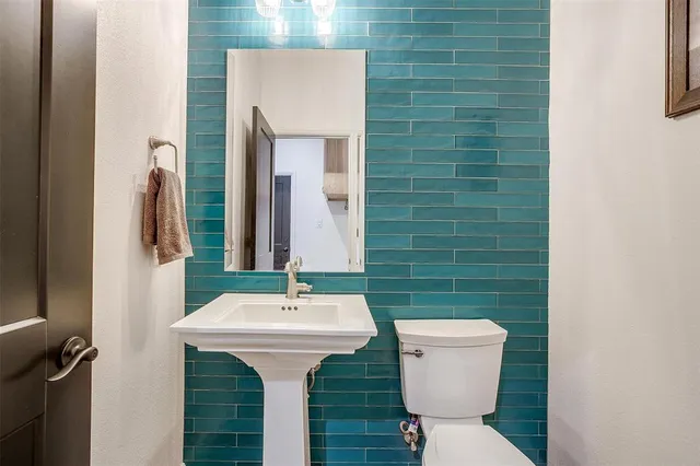 a bathroom with a sink toilet and a mirror