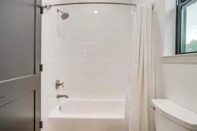 a bathroom with a granite countertop sink toilet and mirror