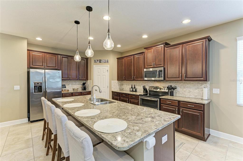 5307 65th Terrace East Ellenton, FL 34222 - Photo 18 of 47 a kitchen with granite countertop a sink a center island stainless steel appliances and cabinets