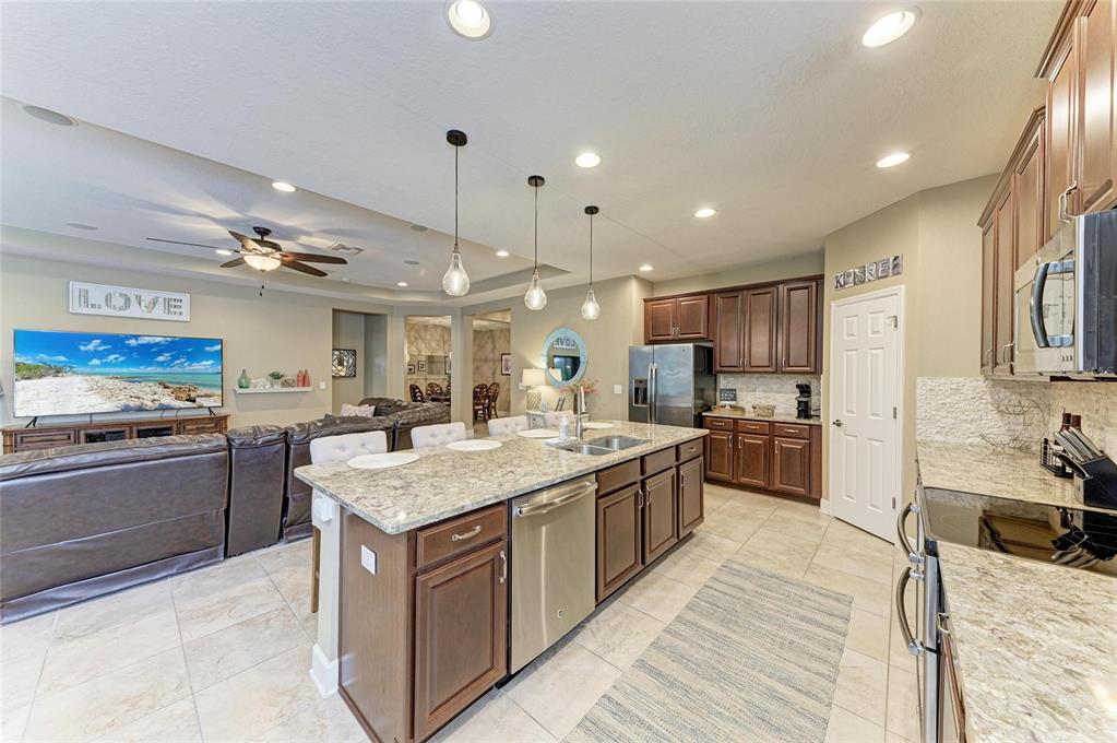 5307 65th Terrace East Ellenton, FL 34222 - Photo 19 of 47 a kitchen with stainless steel appliances granite countertop a stove oven and a refrigerator
