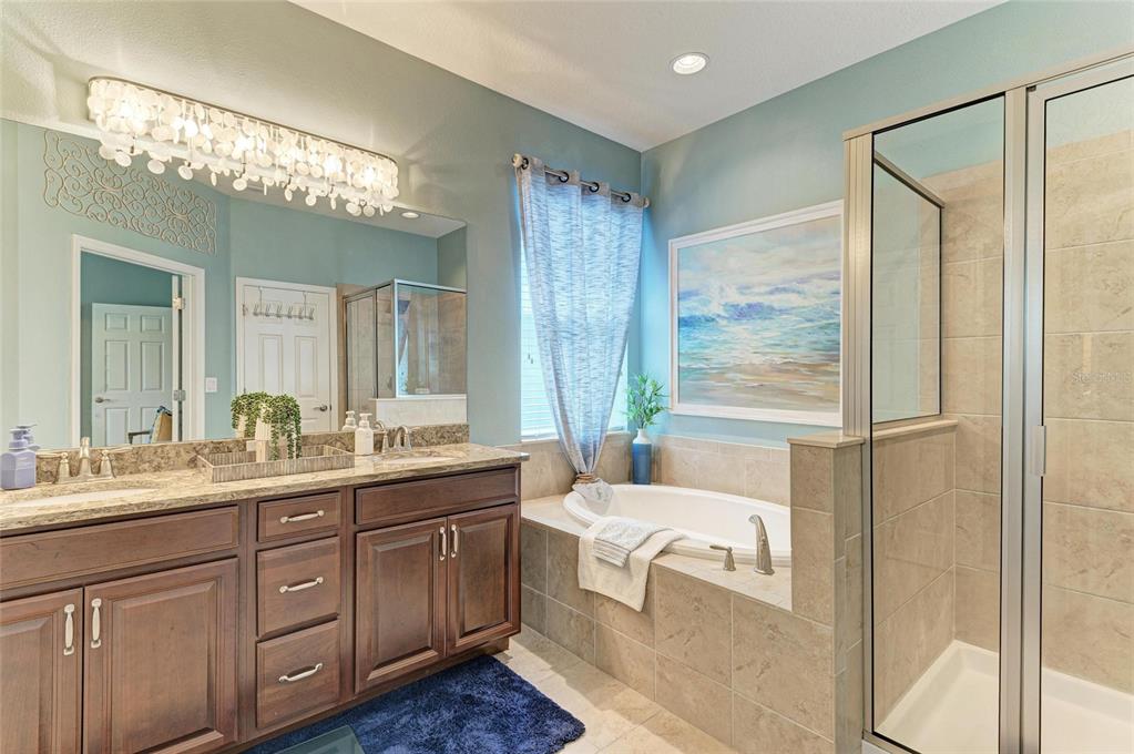5307 65th Terrace East Ellenton, FL 34222 - Photo 33 of 47 a spacious bathroom with a double vanity sink a large mirror and a bathtub