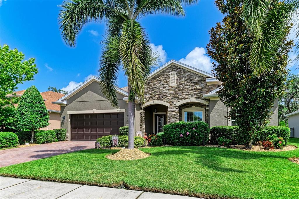 5307 65th Terrace East Ellenton, FL 34222 - Photo 4 of 47 a front view of a house with a garden and yard