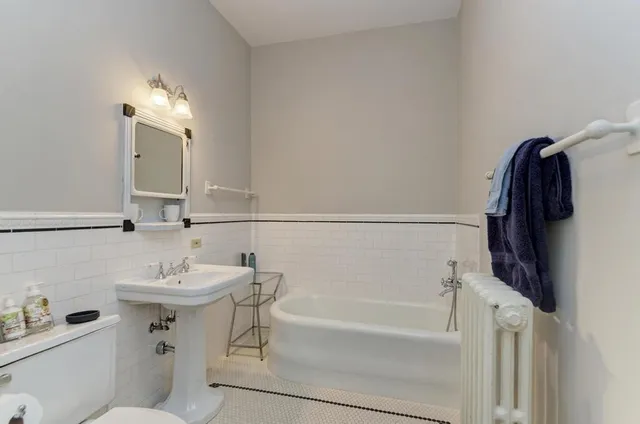 a spacious bedroom with a bed and a chandelier