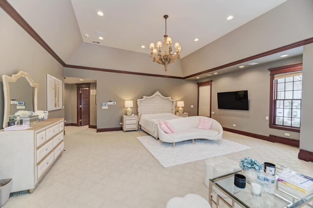 1499 Sheridan Road Highland Park, IL 60035 - Photo 50 of 87 a spacious bedroom with a bed and a chandelier