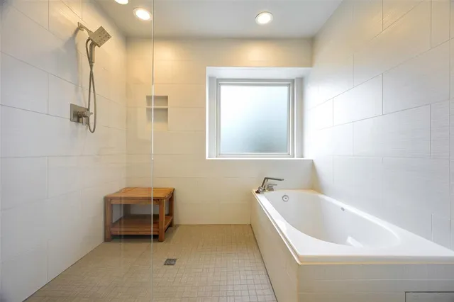 a bathroom with a tub a sink and a window