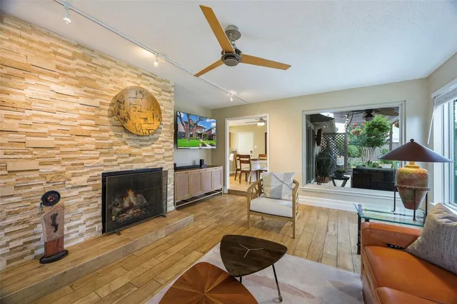a living room with furniture a fireplace and a floor to ceiling window