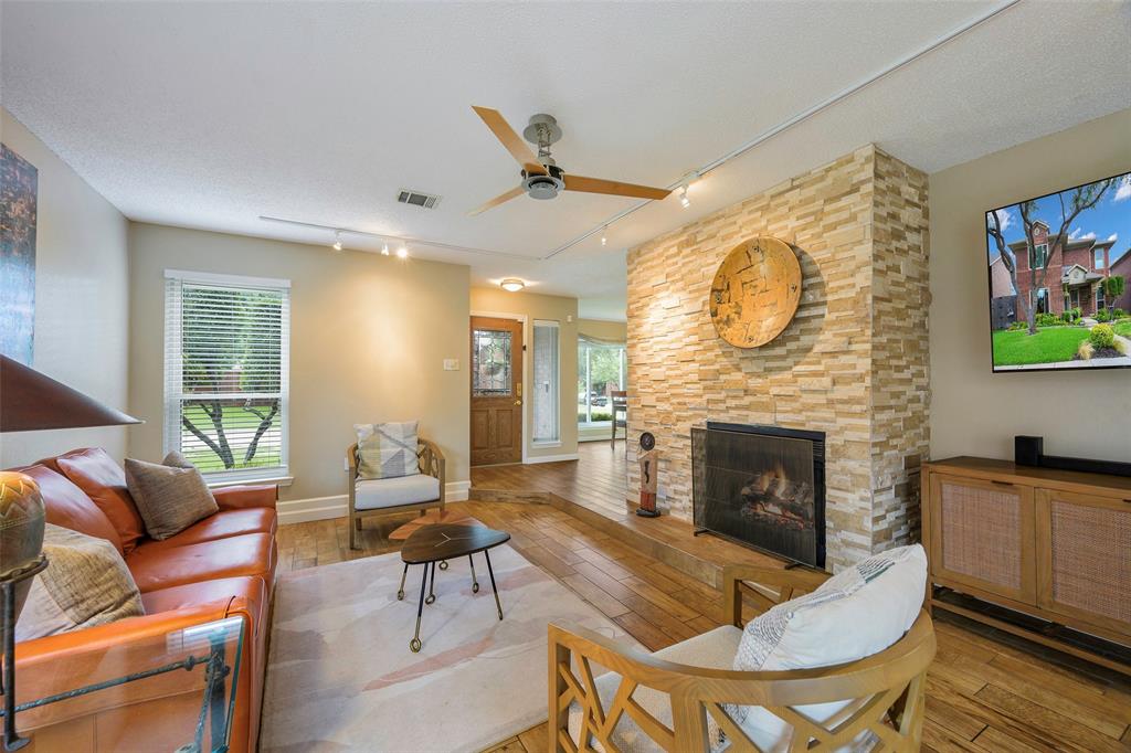 2903 Fort Point Lane Carrollton, TX 75007 - Photo 9 of 27 a living room with furniture a flat screen tv and a fireplace