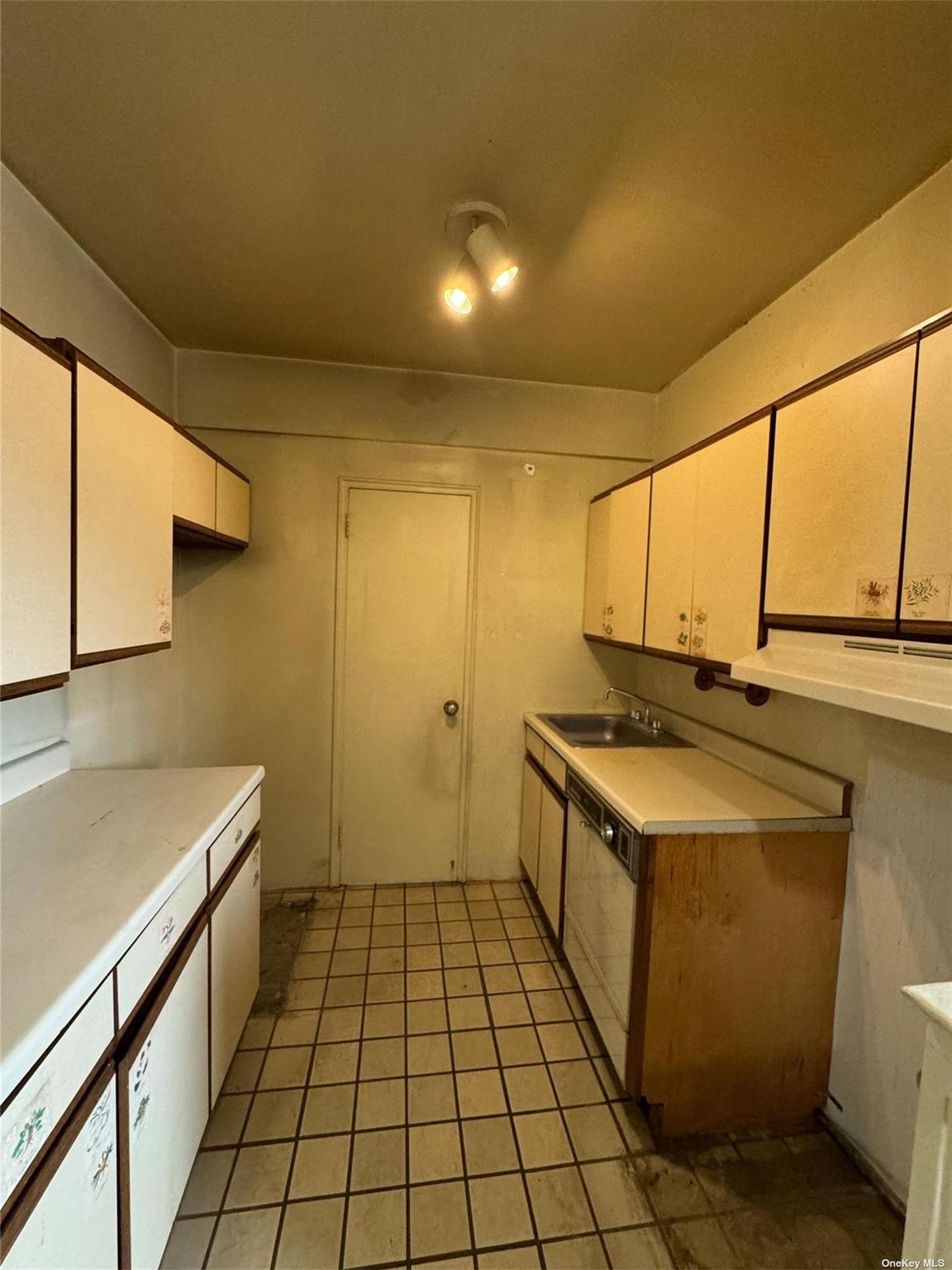67-76 Booth Street, Unit 1G Queens, NY 11375 - Photo 9 of 15 a kitchen with a sink stove and cabinets