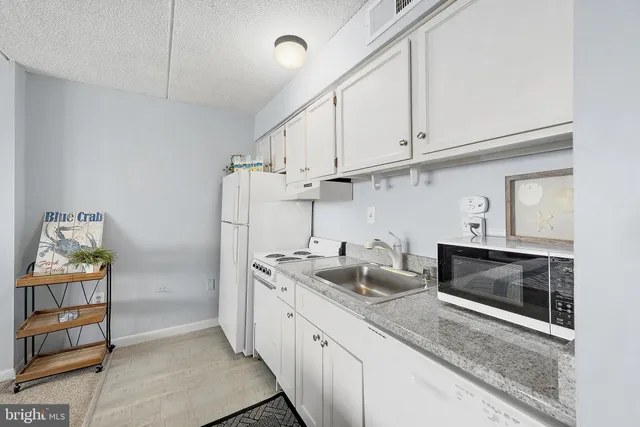 a spacious bedroom with a bed a couch and cabinets