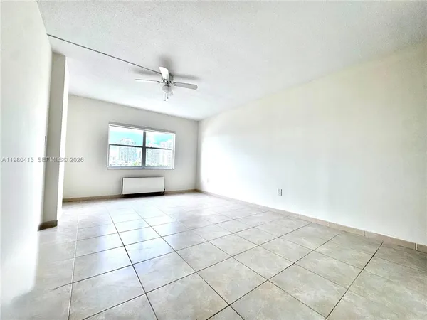 an empty room with windows and cabinet