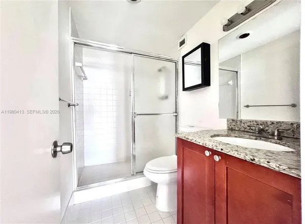 a bathroom with a granite countertop sink toilet and shower