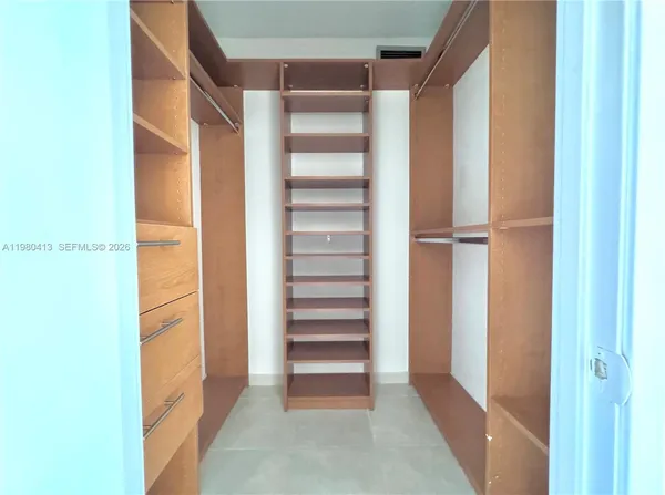 a view of walk in closet with empty racks