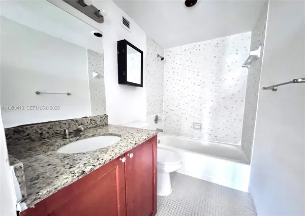 a bathroom with a granite countertop sink a bathtub and a shower