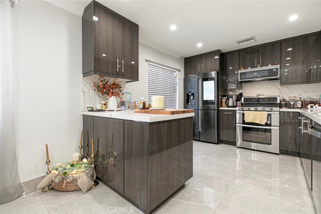 7901 Vía Stefano Burbank, CA 91504 - Photo 11 of 58 a kitchen with kitchen island granite countertop wooden cabinets and stainless steel appliances