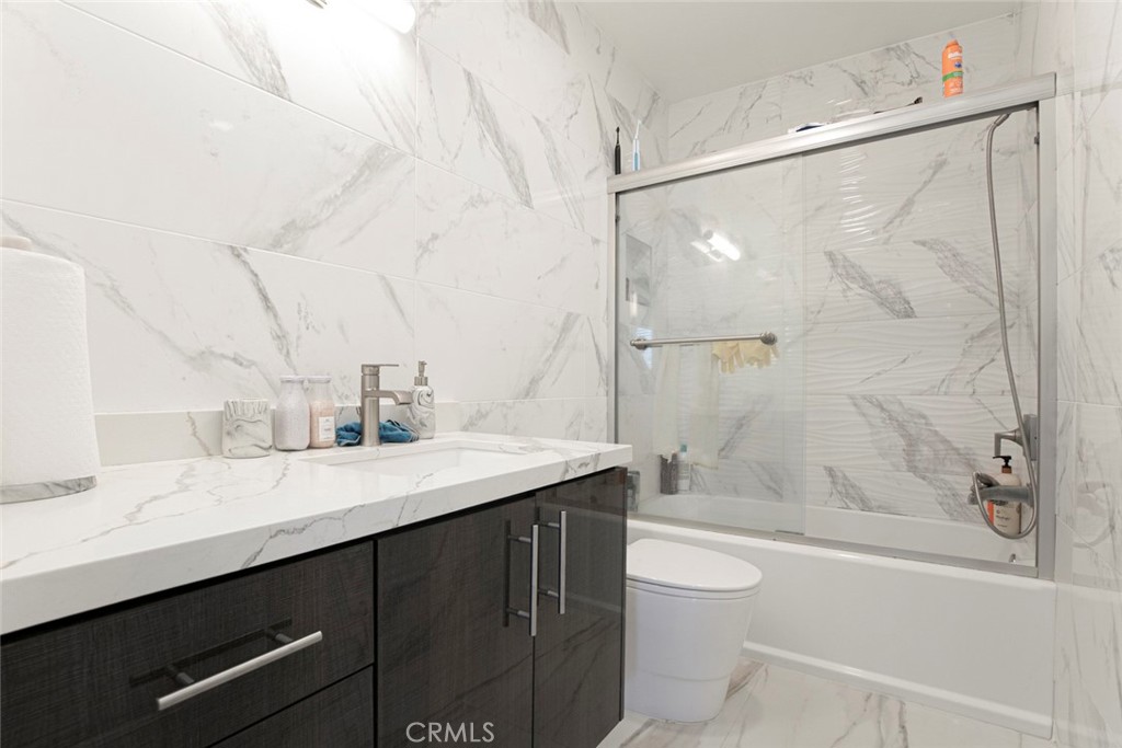 7901 Vía Stefano Burbank, CA 91504 - Photo 29 of 58 a bathroom with a granite countertop sink a toilet and shower