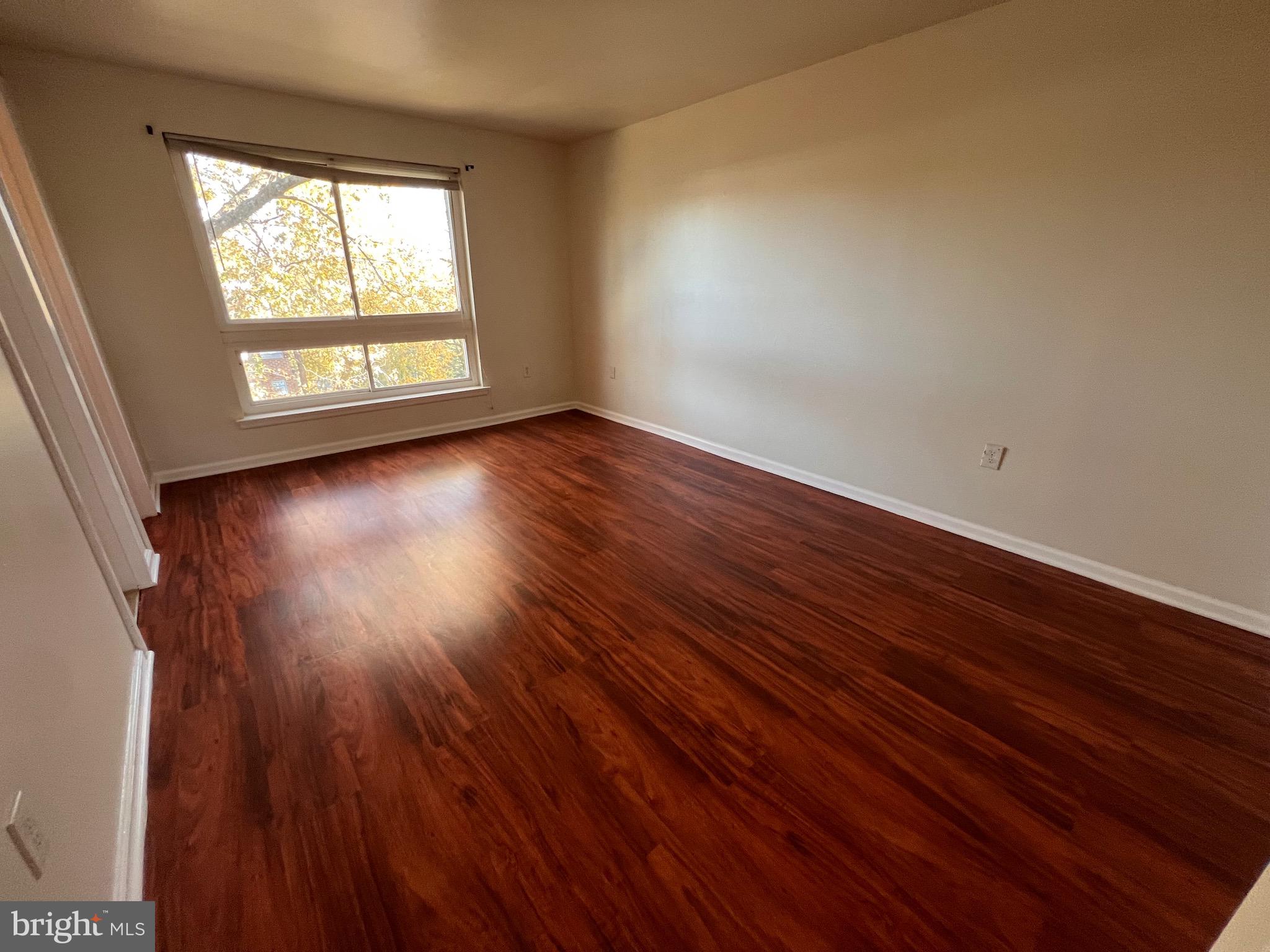 3964 Bel Pre Road, Unit 8 Silver Spring, MD 20906 - Photo 11 of 24 a view of an empty room with wooden floor and a window