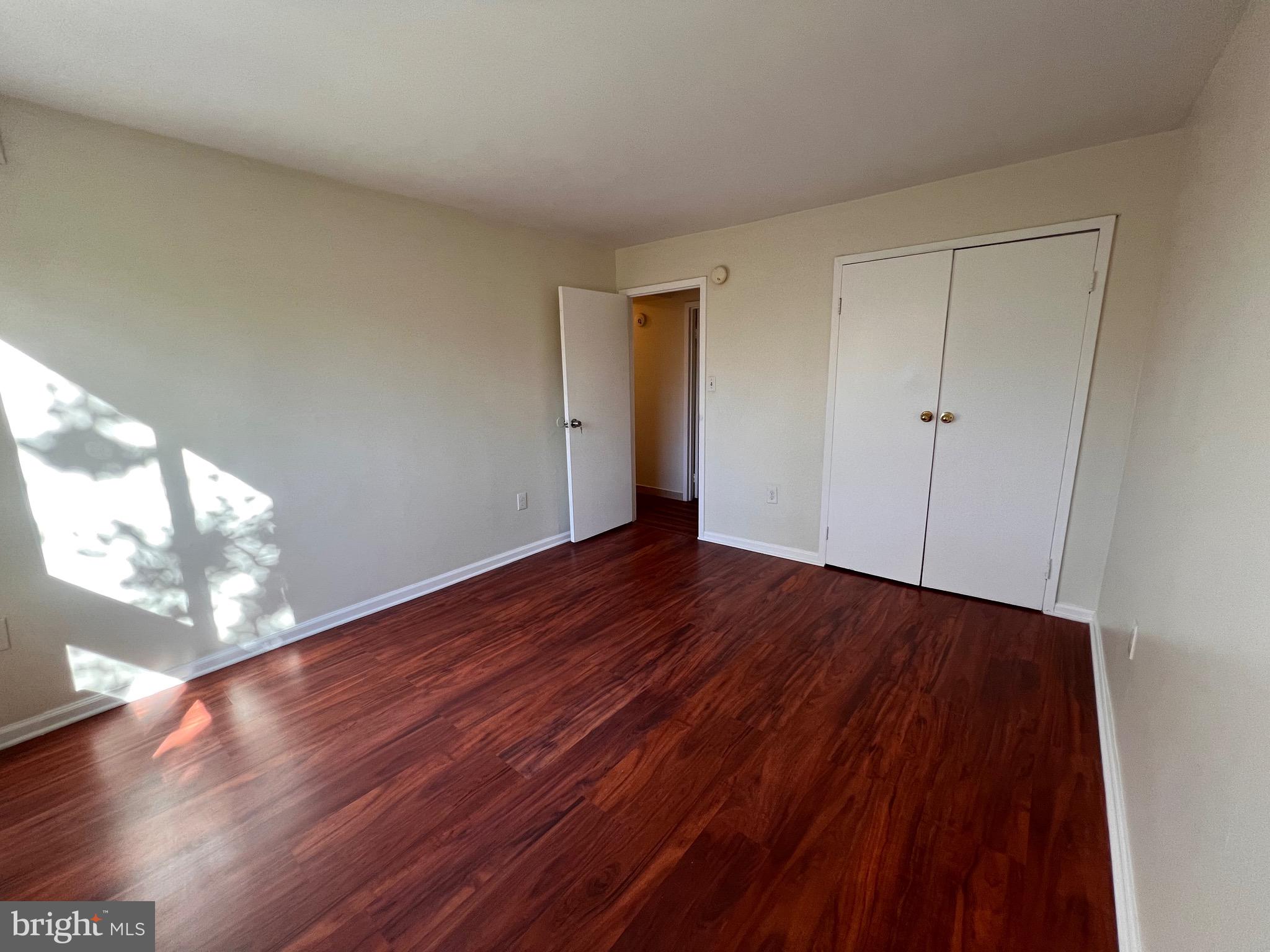 3964 Bel Pre Road, Unit 8 Silver Spring, MD 20906 - Photo 12 of 16 a view of an empty room with wooden floor and a window