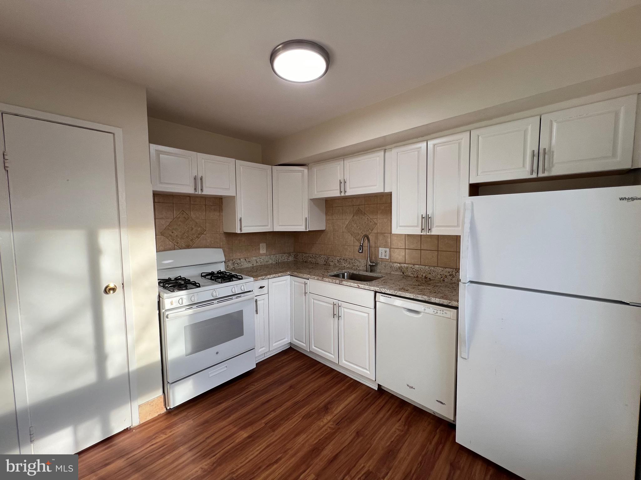 3964 Bel Pre Road, Unit 8 Silver Spring, MD 20906 - Photo 15 of 24 a kitchen with granite countertop white cabinets and white appliances