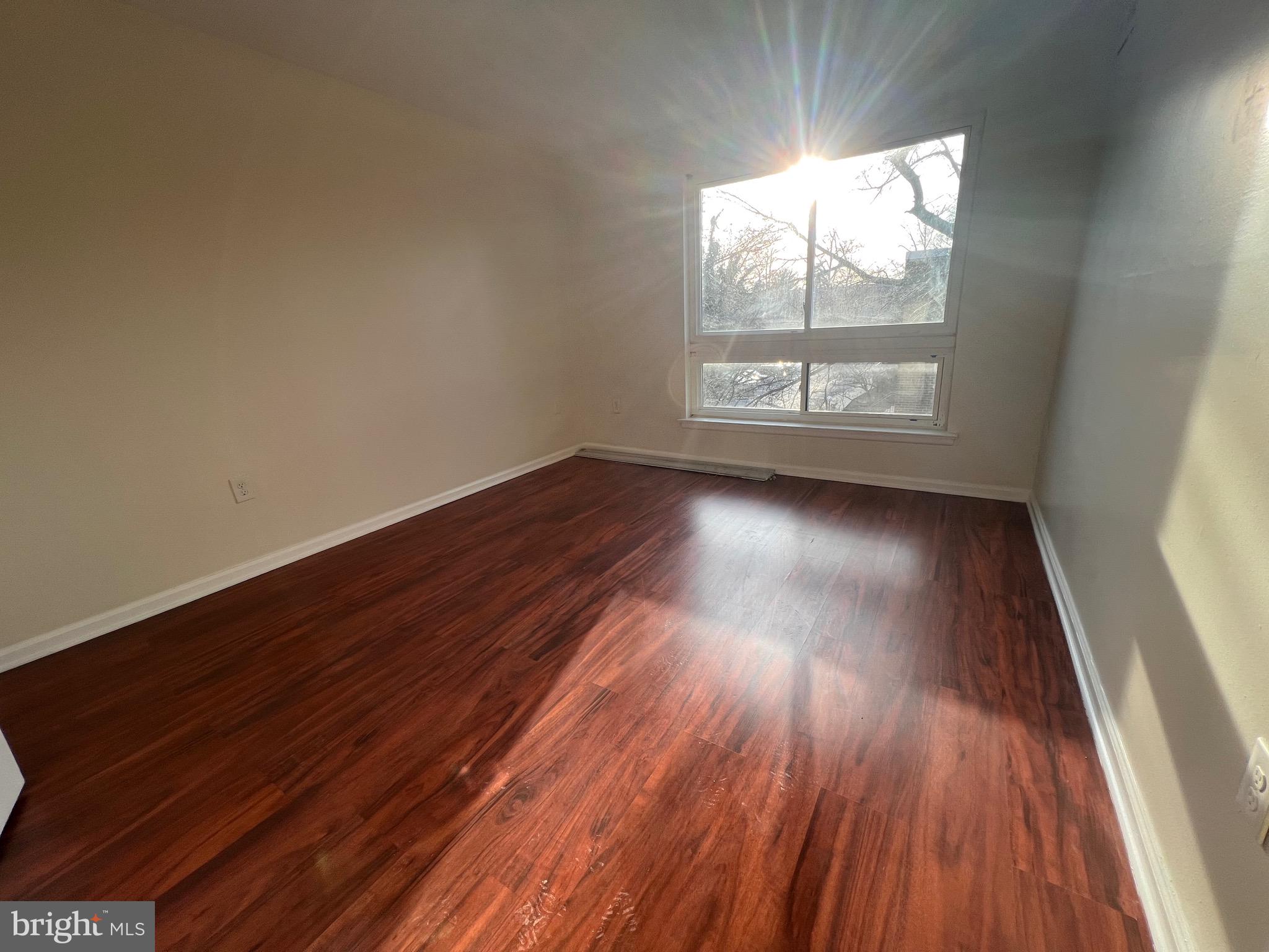 3964 Bel Pre Road, Unit 8 Silver Spring, MD 20906 - Photo 18 of 24 a view of an empty room and wooden floor and window